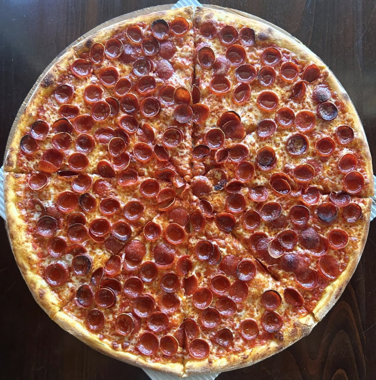 A golden pizza covered in cup-and-char pepperoni.
